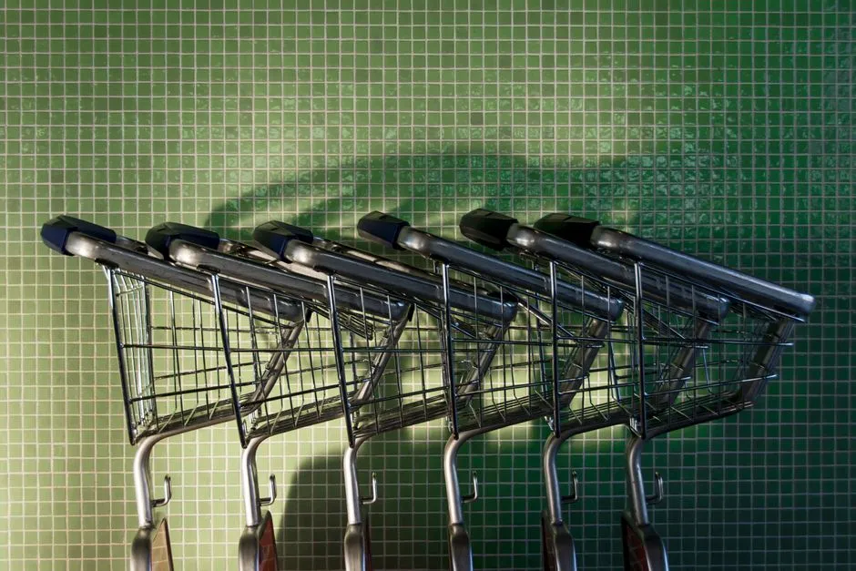 Close-up of empty shopping carts lined up outside a grocery store